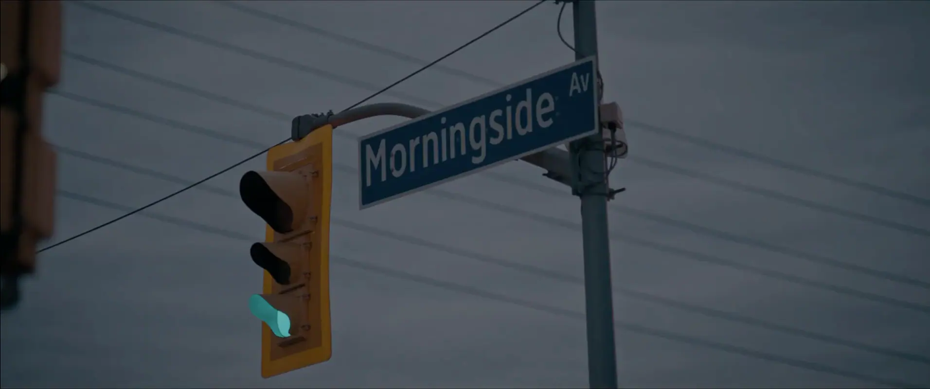 A Morningside Avenue street sign and a green traffic light against an overcast sky.